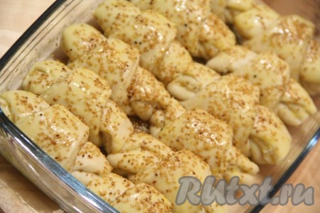 Смазать верх рогаликов молоком, посыпать кунжутом и поставить в разогретую духовку.