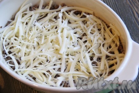  Сыр натереть на крупной тёрке. Половину сыра выложить на гречку.