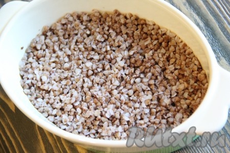 Форму для запекания смазать маслом. Выложить 1 стакан вареной гречки в форму и разровнять.