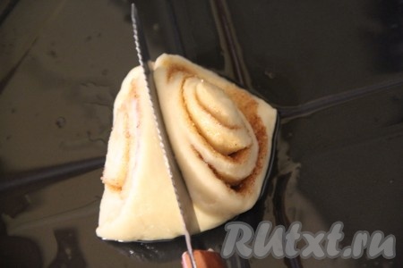 Противень для выпекания смазать растительным маслом. Выложить получившиеся треугольники на противень широкой стороной вниз. Приплюснуть деревянной палочкой или тупой стороной ножа по середине каждую булочку.