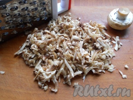 Пока варится картошка, займёмся грибной зажаркой. Для этого шампиньоны нужно вымыть и натереть их на крупной тёрке.