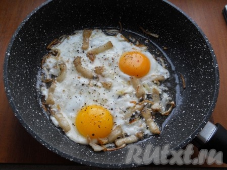 Обжаривать лук с салом на небольшом огне, иногда помешивая, до золотистости лука. Затем в сковороду вбить яйца, посолить (если сало не соленое) и поперчить.
