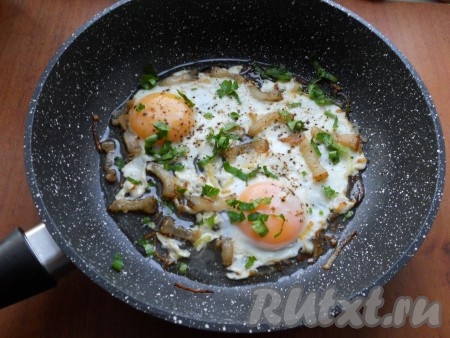 Готовую яичницу посыпать свежей измельченной зеленью.
