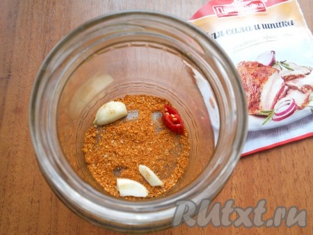 На дно банки всыпать 1-2 зубчика чеснока, чуть раздавленного ножом, немного специй, колечко перца чили.