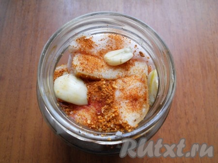 Выкладывать в банку куски сала, пересыпая их специями, перцем чили и чесноком.