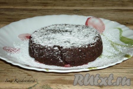 Духовку разогреть до 200 градусов. Отправить запекаться шоколадный фондан на 10 минут (снаружи должна получиться хрустящая оболочка, а внутри - жидкая начинка). Достать формочки из духовки, переложить десерт из формочек на тарелку, по желанию, присыпать сахарной пудрой (я присыпала сахарной пудрой, которая не тает при соприкосновении с горячей выпечкой), а затем горячим подать к столу. Есть шоколадный фондан, приготовленный в домашних условиях, нужно горячим, сразу же как только достали из духовки, иначе  сердцевина затвердеет и фондан больше будет похож на кекс. 