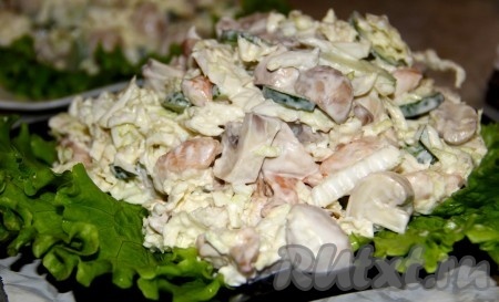 На блюдо выкладываем наш салат с пекинской капустой, шампиньонами и курицей (я выложила салат на тарелку, застеленную листьями салата).
