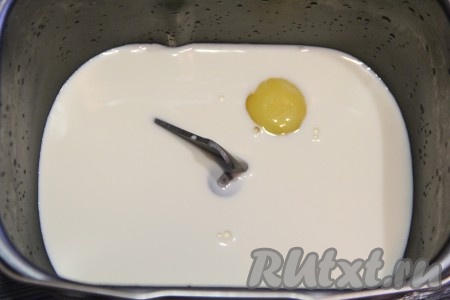 Молоко комнатной температуры, растительное масло и яйцо добавить в ведёрко хлебопечки.
