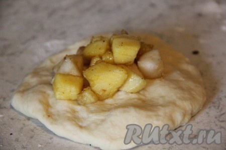 Подошедшее дрожжевое тесто разделить на 15 кусочков (в результате у нас получатся 15 пирожков). На столе, присыпанном мукой, каждый кусочек теста раскатать в лепёшку, на которую выложить часть обжаренных яблок (я мысленно разделила яблочную начинку на сковороде на 15 частей - по количеству пирожков, которые планировала лепить). Защипнуть края каждой лепёшки над начинкой, формируя пирожок.