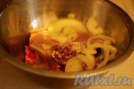 К курице добавляем чеснок с пряностями, уксус, лук.