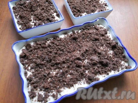 Небольшие формочки для запекания смазать сливочным маслом и выложить в них творожно-шоколадное тесто, посыпать сверху шоколадной крошкой (я посыпала щедро, вы же ориентируйтесь на свой вкус). Формочки с тестом поставить в духовку, разогретую до 180 градусов. Готовить творожную запеканку с шоколадом в течение 30-35 минут. Готовность можно проверить сухой деревянной зубочисткой, для этого сделайте прокол по середине выпечки и достаньте зубочистку, если на зубочистке не останется следов теста, значит выпечка готова.