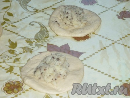 Каждый шарик раскатать в лепёшку, выложить на неё 1 столовую ложку начинки.&nbsp;
