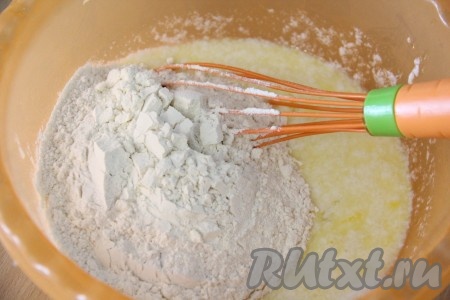 Всыпать разрыхлитель, ванилин и половину муки, перемешать венчиком.