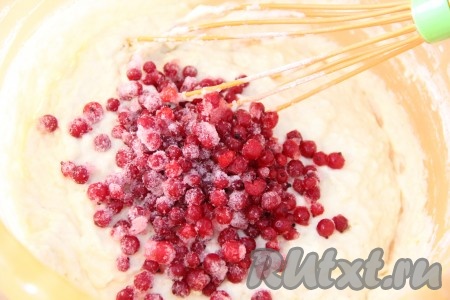 Затем начать по столовой ложке добавлять оставшуюся муку, каждый раз вмешивая её в тесто. Нужно добиться, чтобы консистенция теста напоминала достаточно густую сметану. Как только добились такой консистенции, значит больше муку не добавляйте. Добавить в тесто ягоды смородины и перемешать. Вмешивать ягоды нужно аккуратно, смородина должна равномерно распределиться по всему тесту, но при этом желательно сохранить целостность ягодок.