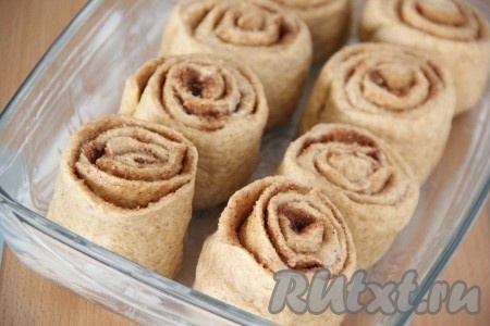 Форму для выпекания смазать сливочным маслом и выложить булочки, накрыть форму полотенцем и оставить в тепле на 40 минут.