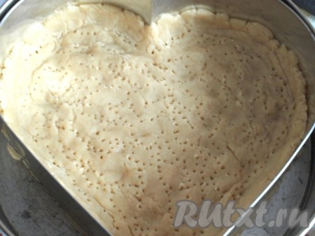 Получившееся песочное тесто равномерно распределить по дну формы для выпечки, сделать бортики высотой около 2 сантиметров. Тесто наколоть вилкой и отправить на 20 минут в духовку, разогретую до 180 градусов.