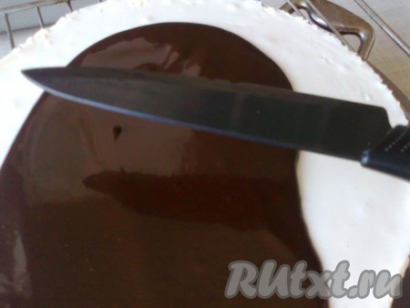 Покрываем поверхность торта зеркальной шоколадной глазурью. Чтобы покрыть зеркальной шоколадной глазурью весь торт, выливаем глазурь на поверхность торта и сгоняем лопаткой (у меня широкий длинный нож) так, чтобы глазурь покрыла бока торта.