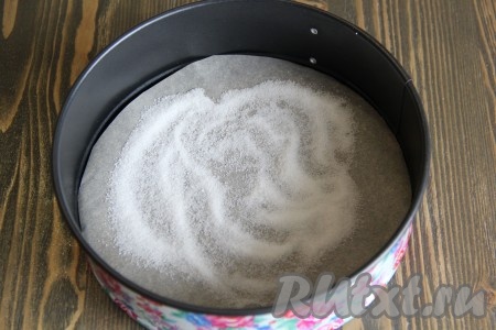  Для выпечки я использовала разъёмную форму диаметром 22 сантиметра. На дно формы выложить круг из пергамента. Присыпать пергамент 1 столовой ложкой сахара.