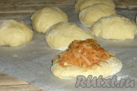 На столе, присыпанном мукой, каждый кусочек теста раскатать в пласт. В центр выложить по 1 чайной ложке начинки.&nbsp;
