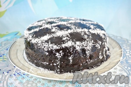 Приготовить шоколадную глазурь: смешать какао-порошок с сахаром, влить молоко, перемешать. Довести на небольшом огне смесь до кипения, периодически помешивая. Добавить сливочное масло и кипятить глазурь на маленьком огне 3-4 минуты. Далее глазурь остудить до комнатной температуры и залить ею торт "Баунти" полностью, разравнивая верх и бока лопаткой. Отправить торт в холодильник на 40-50 минут, посыпать сверху немного кокосовой стружкой и снова поместить тортик в холодильник не менее, чем на 6-8 часов.
