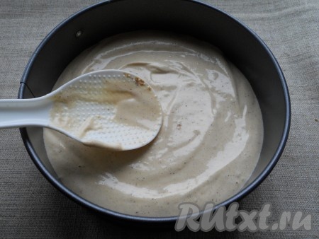 Дно круглой формы диаметром 18-20 сантиметров застелить пергаментом и выложить в неё тесто, разровнять.