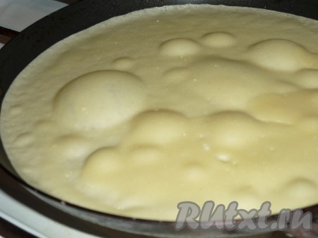 Сковороду немного смазать растительным маслом, хорошо прогреть. Влить в сковороду небольшой половник теста. Распределить тесто по дну сковороды, слегка поворачивая сковороду.