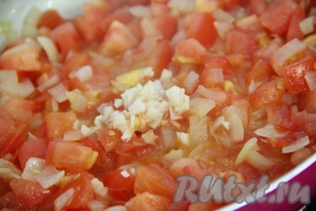 Чеснок очистить и мелко нарезать. Добавить чеснок в сковороду с луком и помидорами. Всё тщательно перемешать, потомить пару минут, а затем снять сковороду с огня.