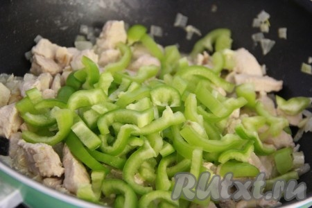 Добавить перец в сковороду и хорошо перемешать с куриным филе и луком.