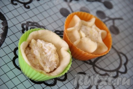 Поместить тесто в силиконовые формы, в середину выложить немного начинки. Защипать края теста так, чтобы в серединке было видно начинку.
