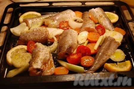 Взять противень, обильно полить его растительным маслом, выложить рыбу и овощи. Сверху посыпать травками, специями, солью, перцем. И отправить в духовку при температуре 200 градусов примерно на 30-40 минут, пока овощи не подрумянятся.