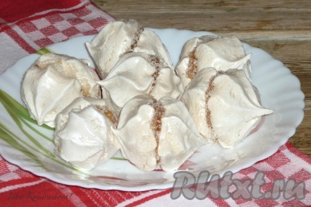 Домашнее безе само по себе получается воздушным и очень вкусным. Я решила сделать из него простые пирожные. Для этого сортируем безе по парам, прослаиваем вареньем и склеиваем по 2 безешки между собой. По желанию присыпаем стык из варенья по кругу кокосовой стружкой.