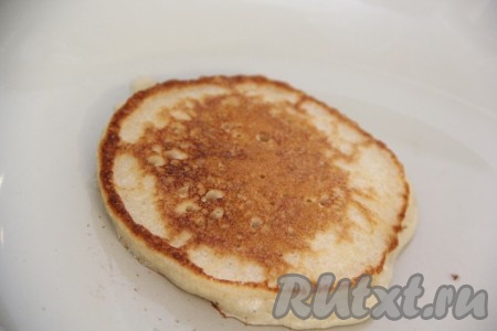 Жарить оладьи на среднем огне с двух сторон до золотистого цвета. Затем переложить на тарелку. Периодически перемешивая тесто, чтобы оно не застаивалось и смазывая сковороду маслом по мере необходимости, постепенно пожарить все оладьи.