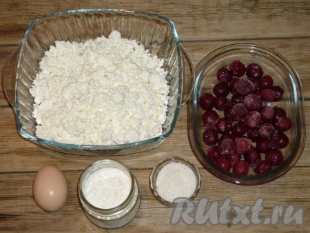 Подготовить продукты для приготовления ленивых вареников из творога с вишней. Вишню можно взять свежую или замороженную. Свежие ягоды нужно будет вымыть, косточки удалить, лишний сок слить. Замороженную вишню нужно разморозить, если есть косточки, их нужно будет удалить, слить лишнюю жидкость. Подготовленную вишню посыпать 2 столовыми ложками сахара, перемешать и оставить на 10-15 минут.