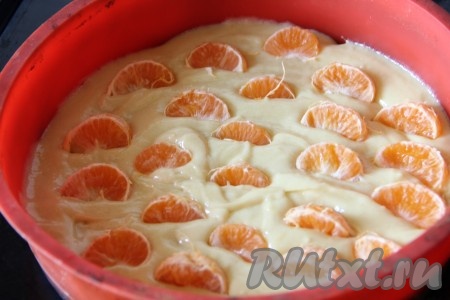 Разъёмную форму для выпечки застелить пергаментом, смазать бока и дно растительным (или сливочным) маслом. Я выпекала в силиконовой форме и просто смазала её растительным маслом. Выложить в форму подготовленное тесто. Мандарины очистить и разобрать на дольки. Мандарины лучше брать без косточек или удалить косточки из долек. На тесто выложить дольки мандаринов и немного утопить.