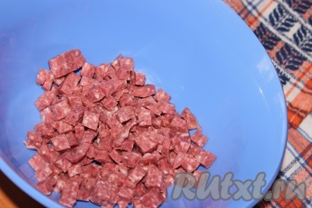 Копченую колбасу нарезать небольшими кубиками.
