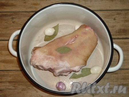 В глубокую кастрюлю выложить рульку, очищенный лук, чёрный или душистый перец горошком, лавровый лист. 