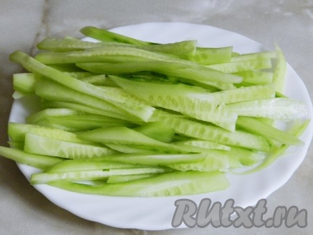 Огурец очистить от кожуры и нарезать соломкой.