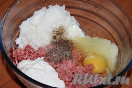 Одну луковицу почистить, помыть и натереть на мелкой тёрке. В большой миске соединить мясной фарш, остывший рис, натёртый лук, вбить яйцо, добавить сметану, посолить и поперчить по вкусу, тщательно перемешать.