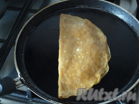 Свободной частью прикрыть блин и снова перевернуть на другую половину.
