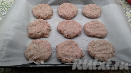 Противень застелить бумагой для выпечки, смазать маслом и выложить на него небольшие круглые лепешки из фарша (диаметром примерно 10 см).
