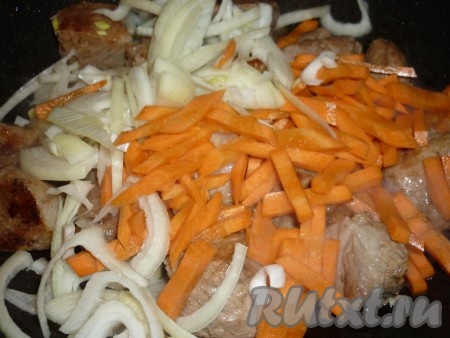 Затем отправить к свинине лук и морковь. Посолить, поперчить по вкусу. 
