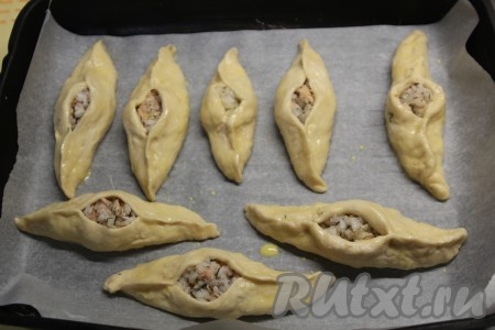 Кладем расстегаи с рыбой на пергамент, смазываем яичным желтком. 
