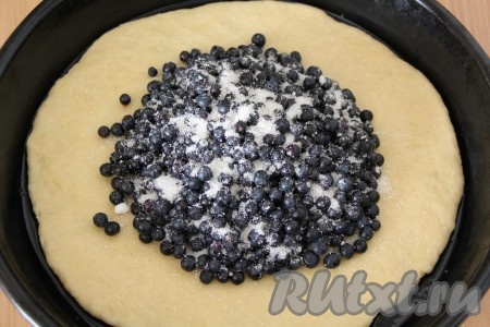 Охладившееся песочное тесто на посыпанной мукой поверхности раскатать скалкой в круг (тонко раскатывать не нужно). Форму для выпечки (или противень) смазать растительным маслом (или застелить пергаментом). Выложить раскатанное тесто на противень. Свежую чернику перебрать, удаляя сор и листочки, промыть водой, обсушить, разложив на бумажном полотенце. Присыпать серединку теста крахмалом (присыпать крахмалом нужно именно ту часть теста, куда будем выкладывать ягодки), выложить обсушенные свежие ягоды на середину теста и присыпать сахаром. Если используете замороженные ягоды, на которых нет большого количества льда, тогда не размораживайте их, а смешайте с крахмалом (в этом случае центр раскатанного теста предварительно посыпать крахмалом не нужно), а затем выложите на тесто и посыпьте сахаром.
