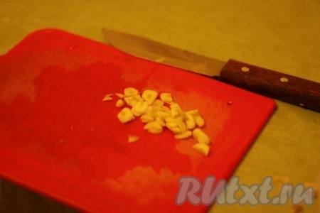 Чеснок нарезать тонкими, но крупными кусочками.