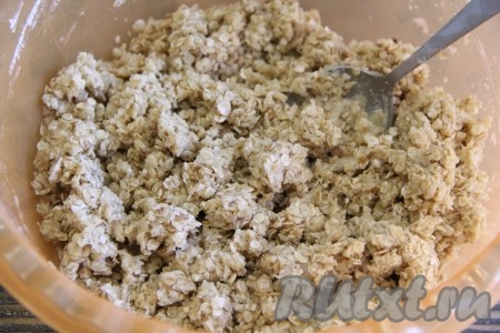 С помощью ложки перемешать овсяную массу. Она должна получиться комковатой, но при этом не сухой. Все сухие ингредиенты должны пропитаться маслом.