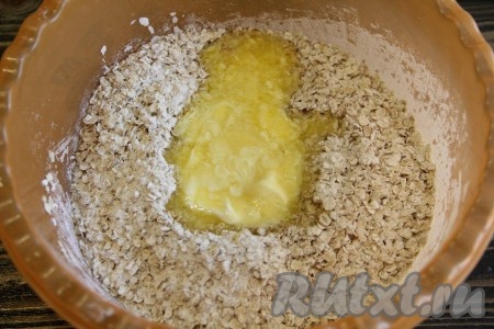 Перемешать сухие ингредиенты. Сливочное масло растопить и слегка остудить. Добавить масло в сухие ингредиенты.