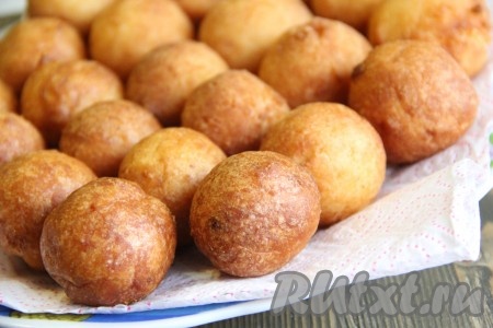  Готовые пончики выкладывать на бумажное полотенце, чтобы удалить излишки масла. Постепенно пожарить все пончики.