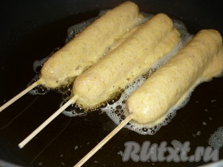 Обмакивать сосиски на палочках в кукурузный кляр и жарить на раскалённом растительном масле (лучше жарить во фритюре, но можно и на сковороде на разогретом растительном масле).&nbsp;