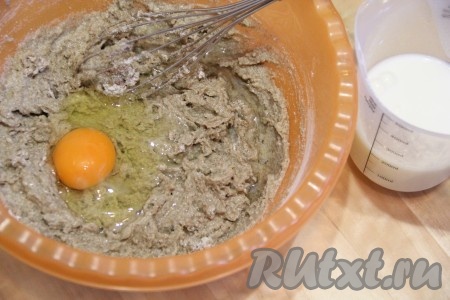 Влить в мучную смесь 200 мл молока и хорошо перемешать венчиком, затем добавить яйцо и снова перемешать. 