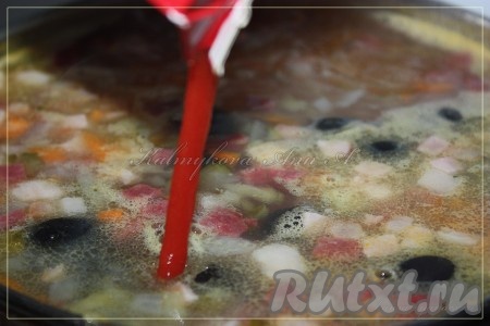 Минут через 5 после закипания воды с овощами добавить колбасные изделия, соленые огурцы, маслины и протертые томаты.
